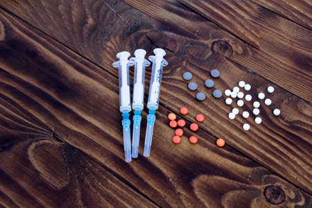 Medical drugs, syringes and pills on a dark backgroundの写真素材