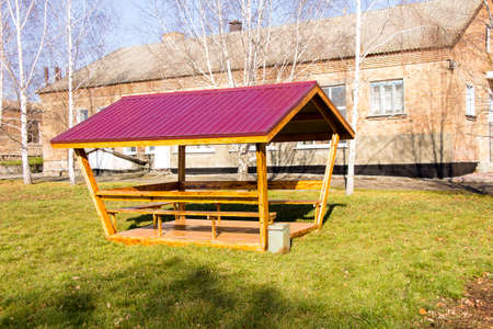 A wooden gazebo with a red roof stands in the courtyard of an educational institution Ukraineの写真素材