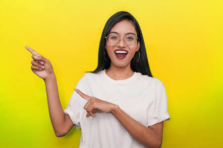 Advertising concept. young Indian girl points her finger to the sides with copy space for your...