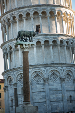 The leaning tower in Pisa and in front of it the wolf mother with romulus and remusの写真素材