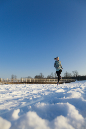 Femal runs from right to left in winter landscape portrait modeの写真素材