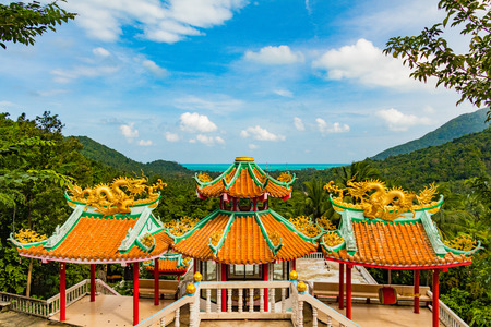 Traditional Thai decorated Buddhist temple on a mountain with ocean in the background and jungle in the foreground, Chinese Temple, Koh Phangan, Thailandの写真素材