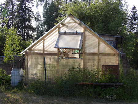 Abandoned farmhouse in the forest. The house is covered with plastic film.の写真素材