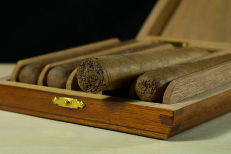 A box of cigars put on plank isolate on black background.の写真素材