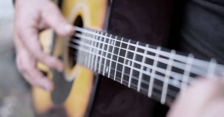 man playing classical acoustic guitar close-up