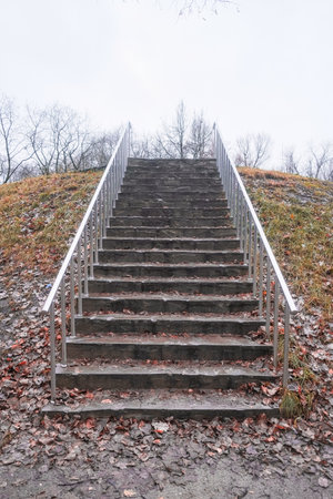 stone staircase up with metal railings in autumn in cloudy weather