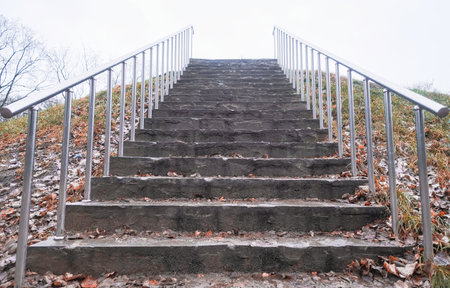 stone staircase up with metal railings in autumn in cloudy weather