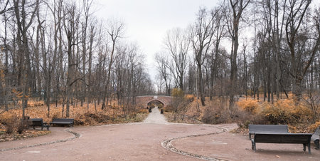 red brick arch on an alley in a beautiful autumn park in cloudy weather