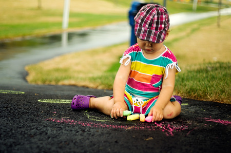 CanadaGirl drawing on the pavement with colored chalkの写真素材