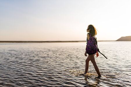 Happy carefree sportly woman enjoying beautiful sunset on the beach