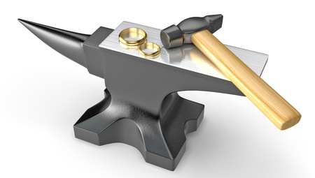 Two golden wedding rings on a metal anvil isolated on white backgroundの写真素材