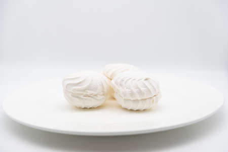 White marshmallows on a white plate on a white background.の写真素材