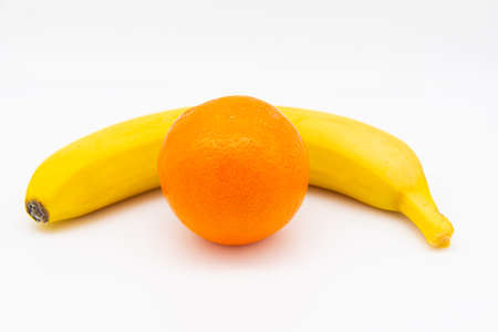 yellow banana and orange on white background. High quality photo. copy space for textの写真素材