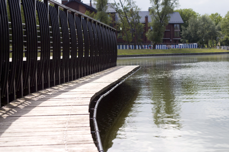 lake with wooden floor for resting in a parkの写真素材