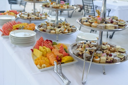 Various fruits and pastries displayed on silver traysの写真素材