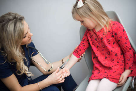 Coronavirus vaccination. Covid-19 vaccine. Doctor vaccinating child. Kids at clinic. Little boy getting flu shot. Pediatrician examining kid and giving injection. Virus prevention. Health care.の写真素材