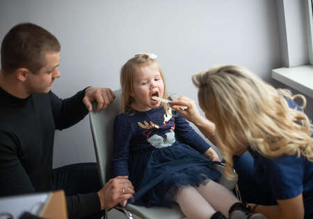 Father with girl being examined by friendly female pediatrician in clinicの写真素材