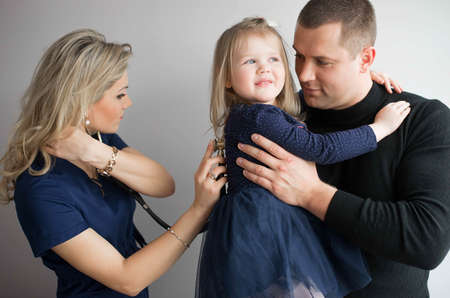 Father with girl being examined by friendly female pediatrician in clinicの写真素材