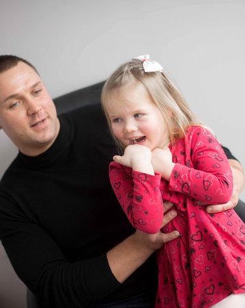 Emotional portrait of father and little  daughter on a gray studio backgroundの写真素材