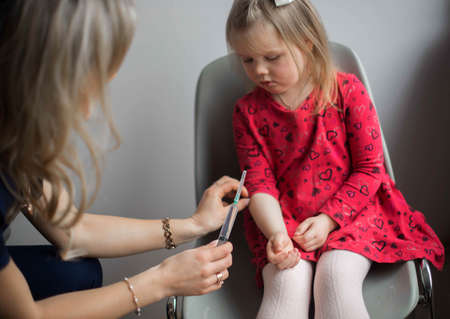 Coronavirus vaccination. Covid-19 vaccine. Doctor vaccinating child. Kids at clinic. Little boy getting flu shot. Pediatrician examining kid and giving injection. Virus prevention. Health care.の写真素材