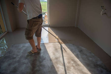Self-leveling epoxy. Leveling with a mixture of cement floors. Epoxy floor application process.の写真素材