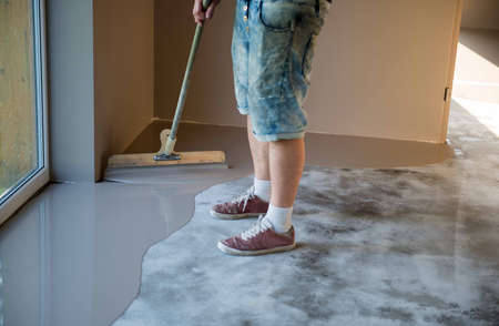 Self-leveling epoxy. Leveling with a mixture of cement floors. Epoxy floor application process.の写真素材