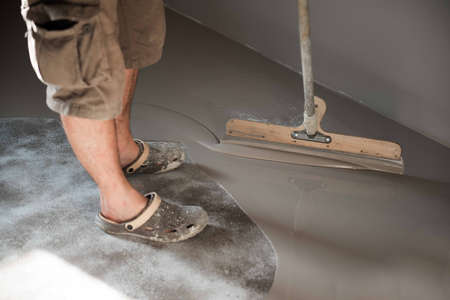 Self-leveling epoxy. Leveling with a mixture of cement floors. Epoxy floor application process.の写真素材