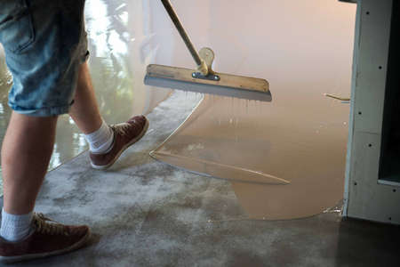 Self-leveling epoxy. Leveling with a mixture of cement floors. Epoxy floor application process.の写真素材