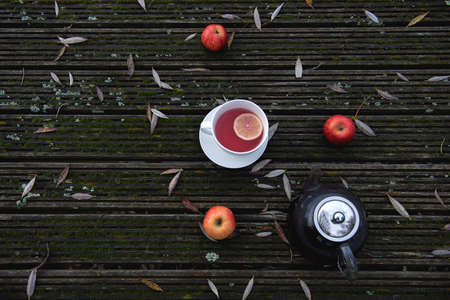Hot fruit tea with lemon slice in white mug on woodenbackground, cozy hot winter drink conceptの写真素材