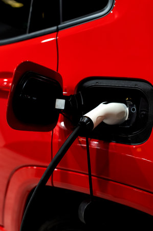 Closeup of power supply plugged into an modern electric car. Electric or EV car charging station.の写真素材