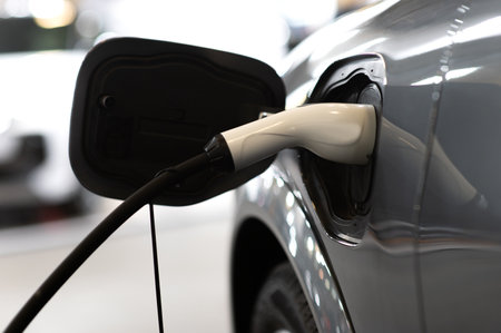 Closeup of power supply plugged into an modern electric car. Electric or EV car charging station.
