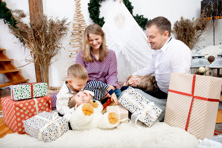 Happy family with three children celebration Christmas on decorated background at home.Happy childhood, parenthood, happy holiday and family concept.の写真素材