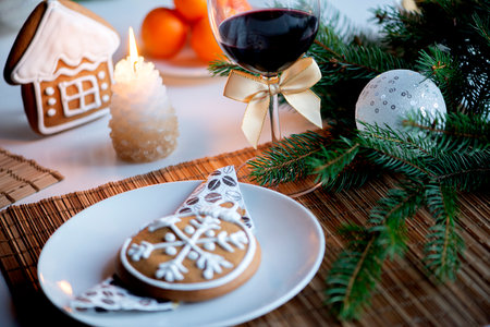 festive Christmas mood with a glass of wine and a burning candle on the kitchen dinner tableの写真素材