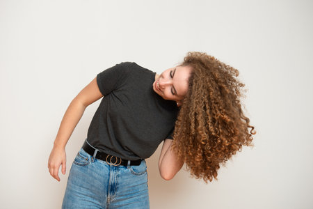 attractive young female with brown curly hairstyle over white background