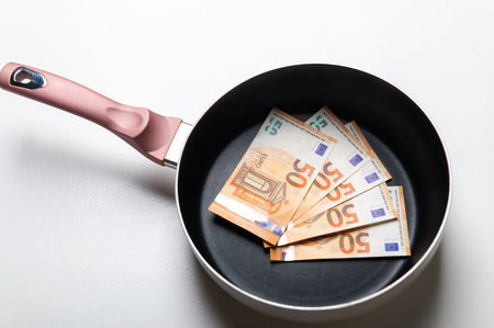 New frying pan with money euro banknotes on a white background.の写真素材