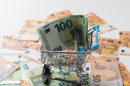 Shopping trolley for a supermarket is filled with euro bills. European financial concept. Shopping with money. Online e-commerce.の写真素材