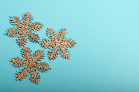 Golden snowflakes on a pastel green backgroundの写真素材