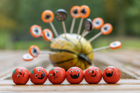 Halloween decoration background with  pumpkin and row of round candies with happy and andry emotion...
