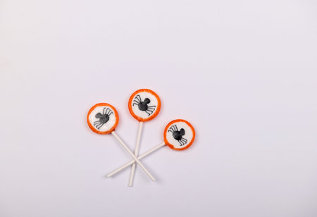 Halloween candy with black spiders isolated on white backgroundの写真素材