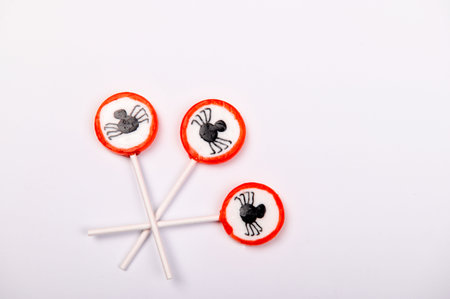 Halloween candy with black spiders isolated on white backgroundの写真素材