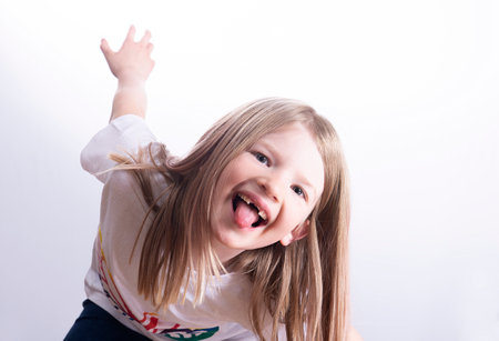 little funny girl without front teeth shows tongue isolated on white backgroundの写真素材