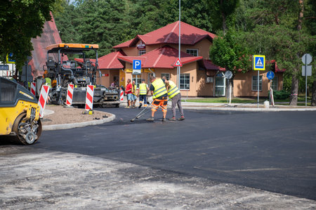 August 4, 2021: Construction site is laying new asphalt road pavement,road construction workers and road construction machinery scene in Sigulda,Latviaのeditorial素材
