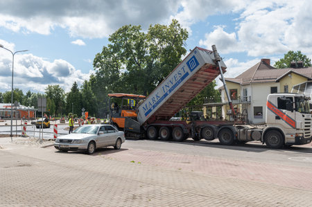 August 4, 2021: Construction site is laying new asphalt road pavement,road construction workers and road construction machinery scene in Sigulda,Latviaのeditorial素材