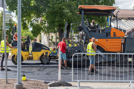August 4, 2021: Construction site is laying new asphalt road pavement,road construction workers and road construction machinery scene in Sigulda,Latviaのeditorial素材