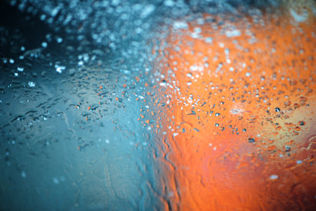 Abstract background with rain drops and snowflakes on car window, wet glass, rainy day.の写真素材