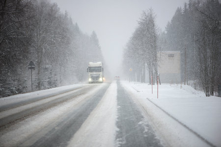 Blurred background of a moving truck on a highway in winter. Freight transport. transportation of goods.の写真素材