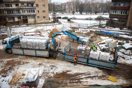 RIGA, LATVIA - FEBRUARY 23, 2021:Delivery and unloading from truck of aerated concrete blocks building material at the construction siteのeditorial素材
