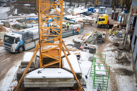 RIGA, LATVIA - FEBRUARY 23, 2021: View of construction site with workers, building materials and a truckのeditorial素材