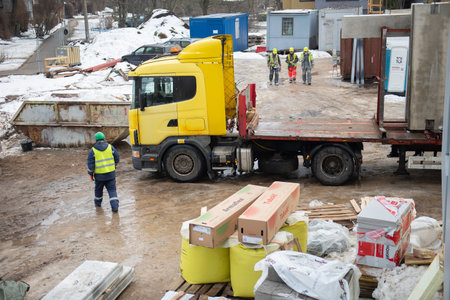 RIGA, LATVIA - FEBRUARY 23, 2021: View of the construction site with workers, building materials and a truckのeditorial素材