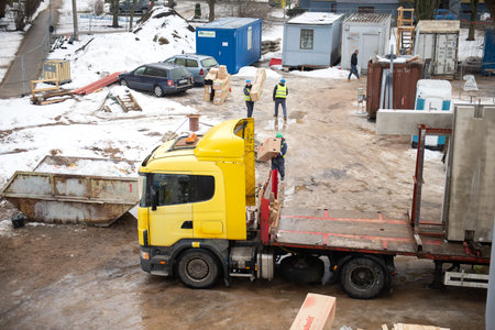 RIGA, LATVIA - FEBRUARY 23, 2021: View of construction site with workers, building materials and a truckのeditorial素材